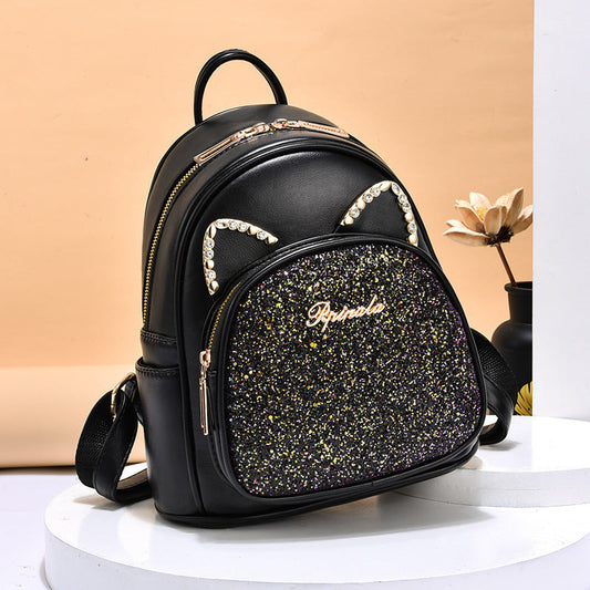 Black backpack with glittery front panel and cat ears on a beige background