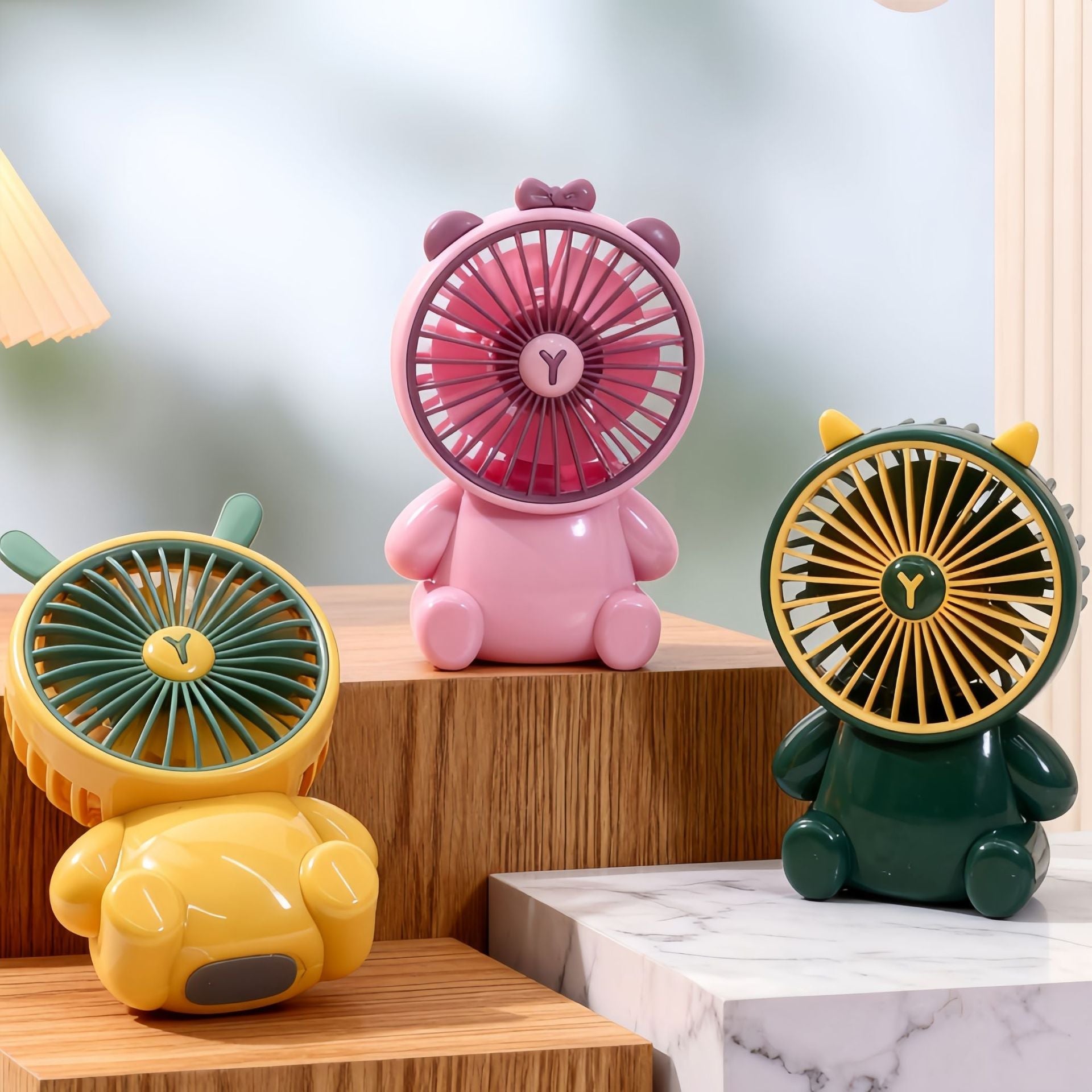Three colorful fan-shaped figurines on a wooden surface with a blurred background