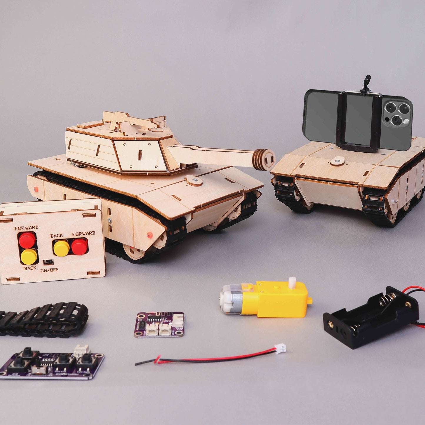 Wooden tank model with remote control components on a gray surface