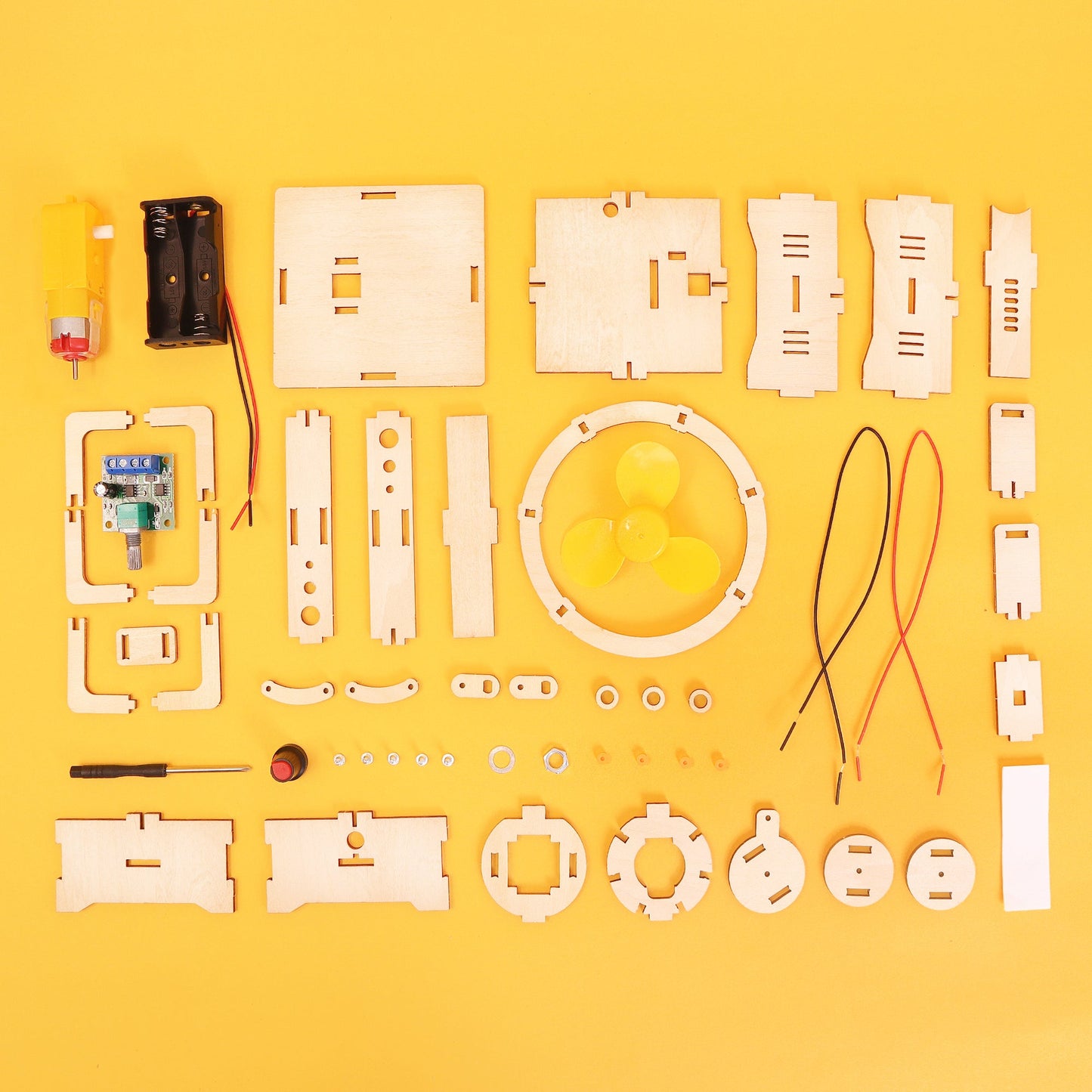 Set of wooden electronic components and tools on a yellow background