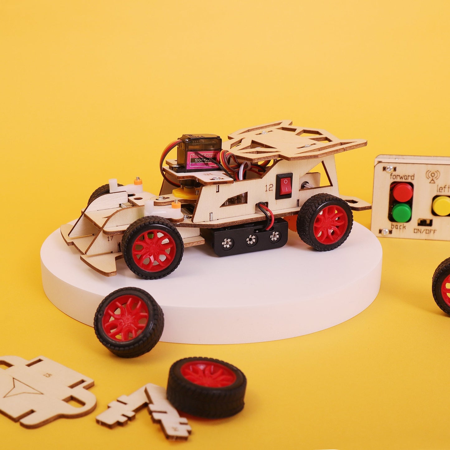Wooden robot model on a yellow background with control panel and wheels.