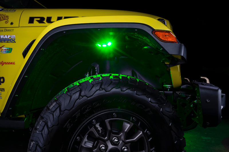 Close-up of a yellow off-road vehicle with green underbody lights, on a dark background.