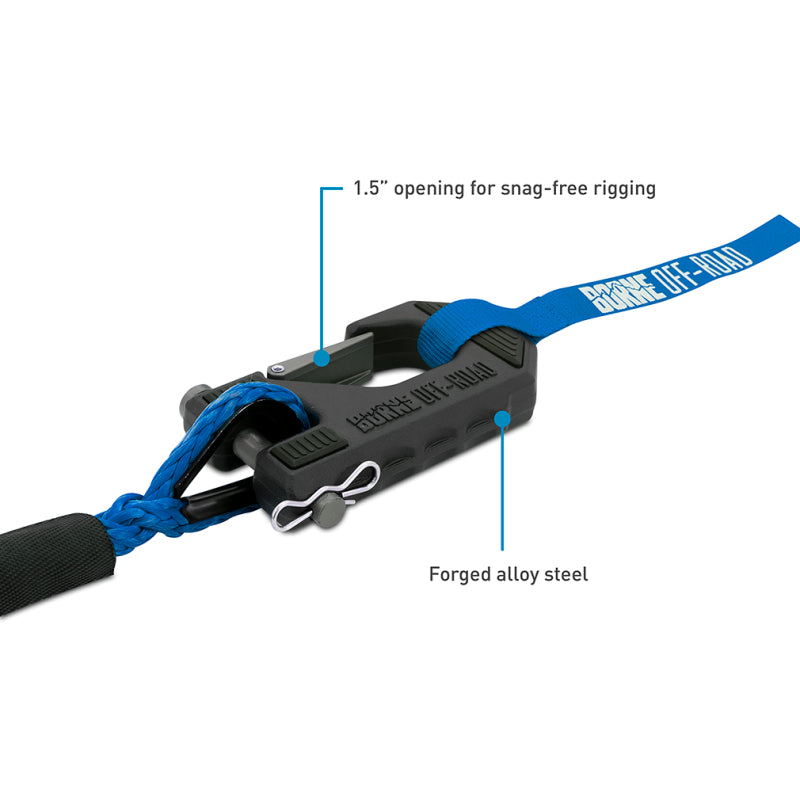 Close-up of a blue strap with a black metal clip on a white background, highlighting features like '1.5" opening for snag-free rigging' and 'Forged alloy steel'.