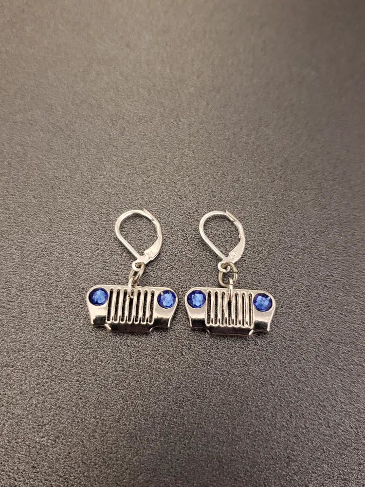 Pair of silver earrings with blue stones on a gray background