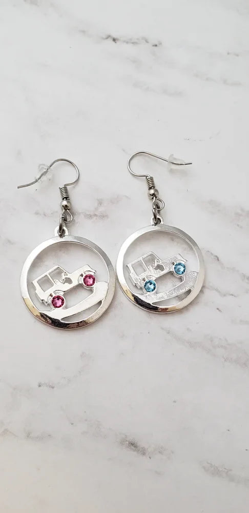 Silver earrings with circular designs on a marble surface