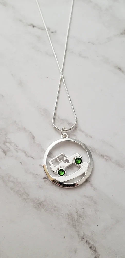 Silver necklace with a round pendant on a marble surface
