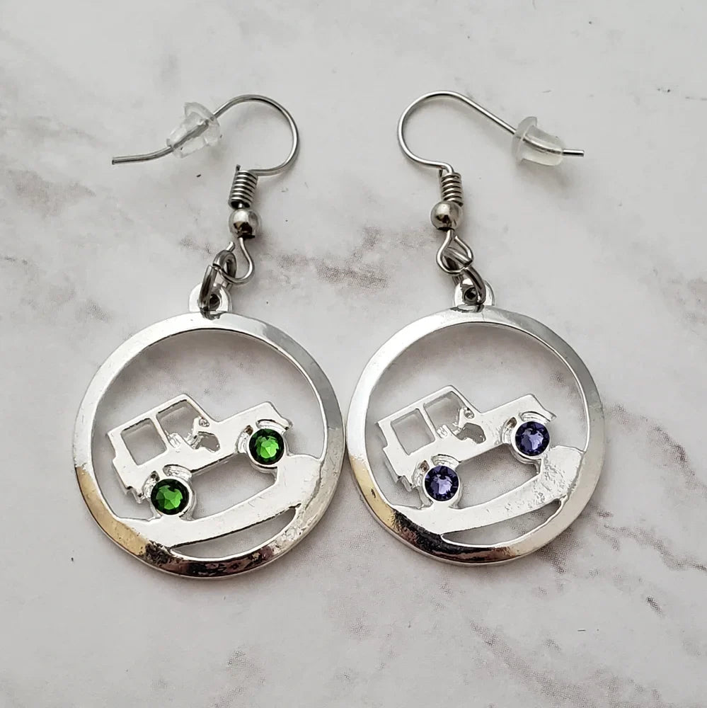 Silver earrings with gemstone accents on a marble surface