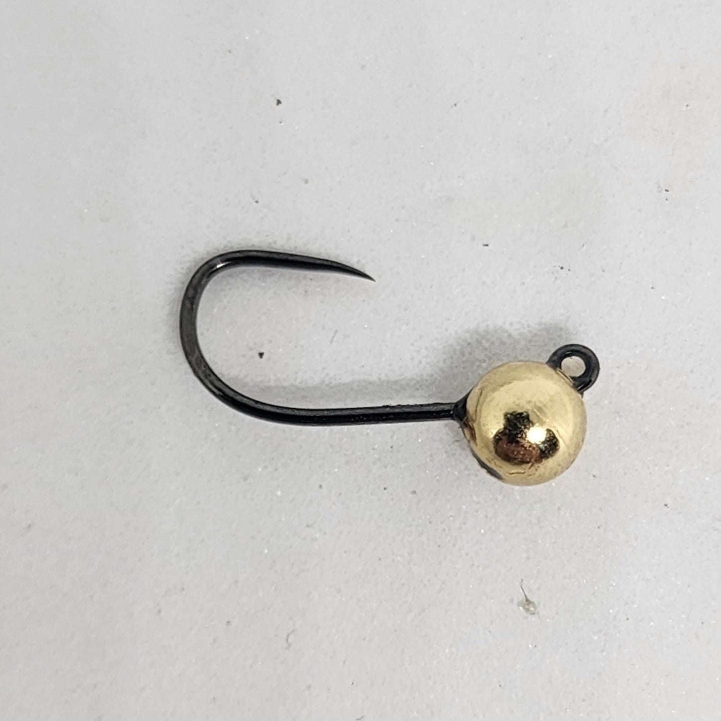 Fishing hook with a gold bead on a light gray background