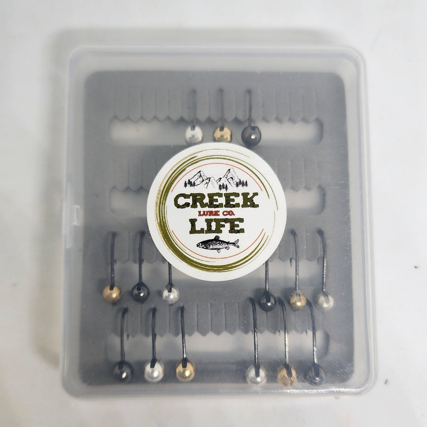 Fishing lure set in a clear container with 'Creek of Life' branding on a white background.