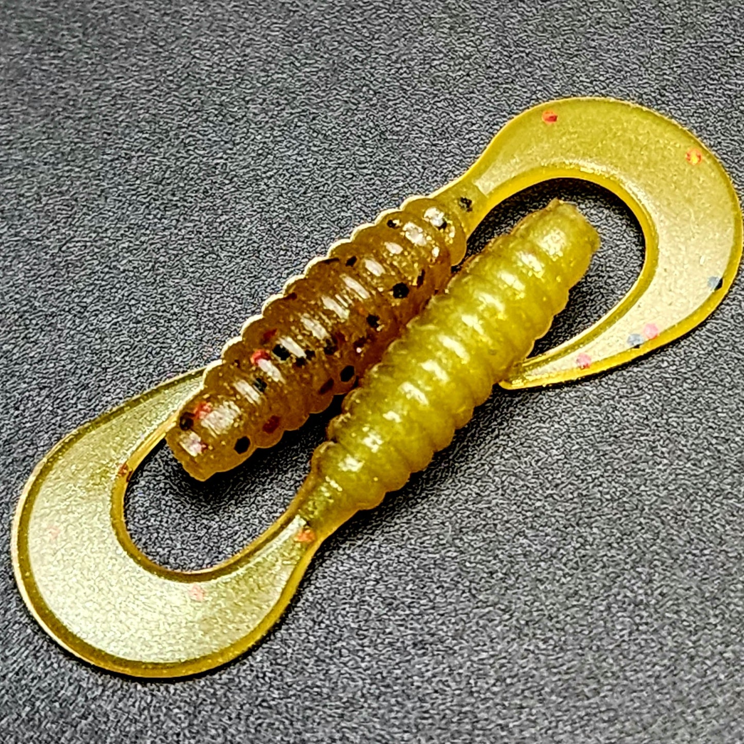 Yellow fishing lure with a hook on a gray background