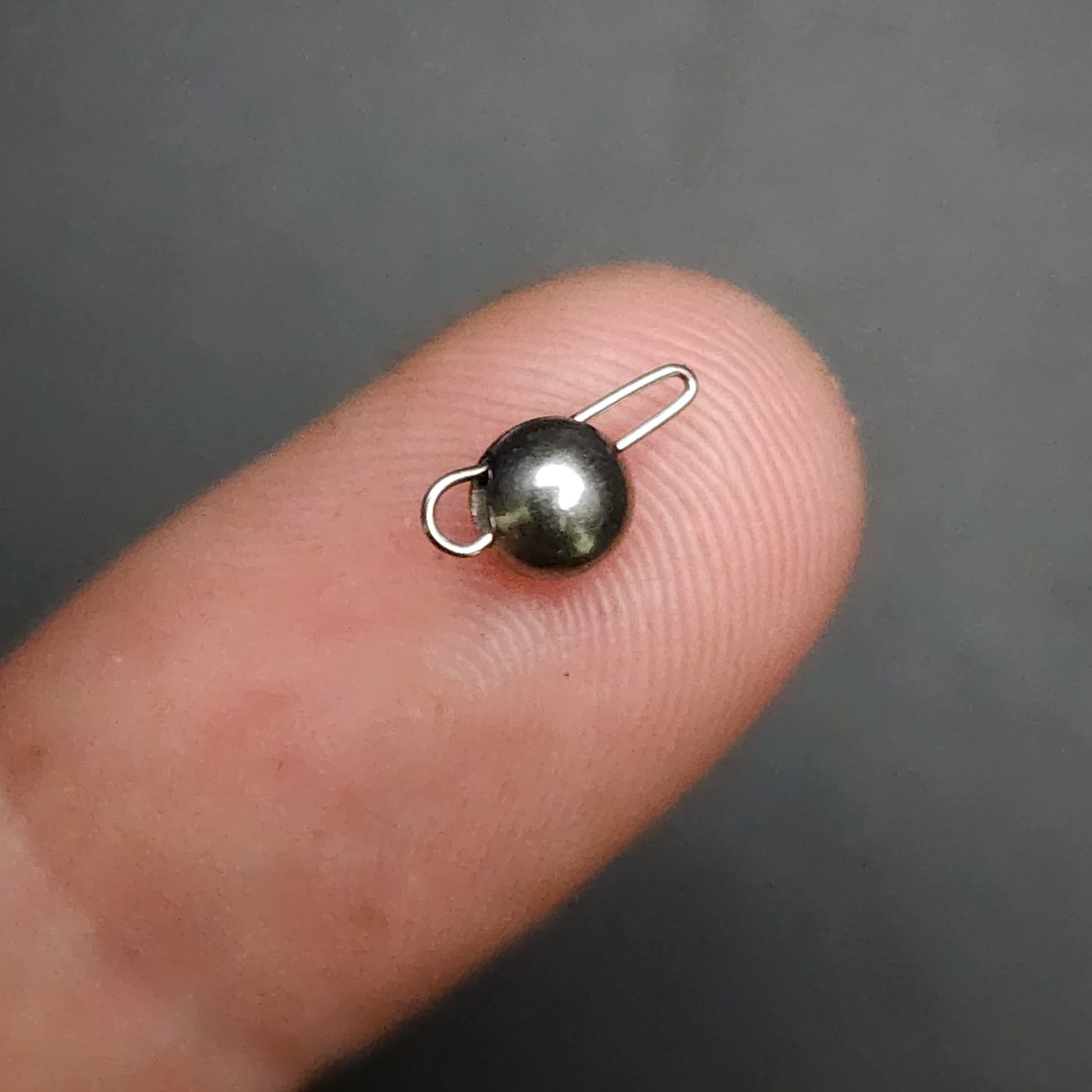 Sinker on a finger against a dark background