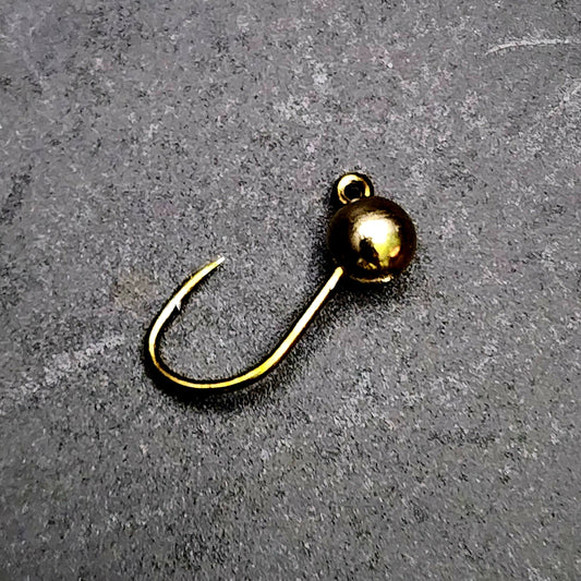 Gold fishing hook on a gray surface
