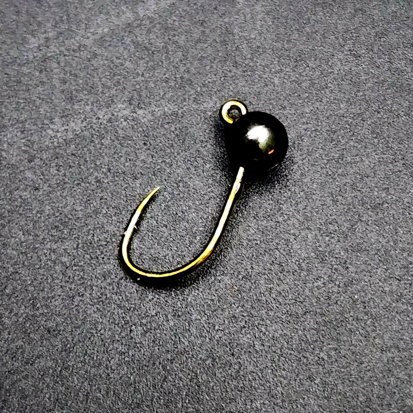 Fishing hook jig on a gray surface