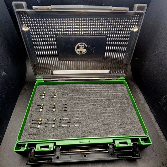 Open case with fishing lures on a dark surface