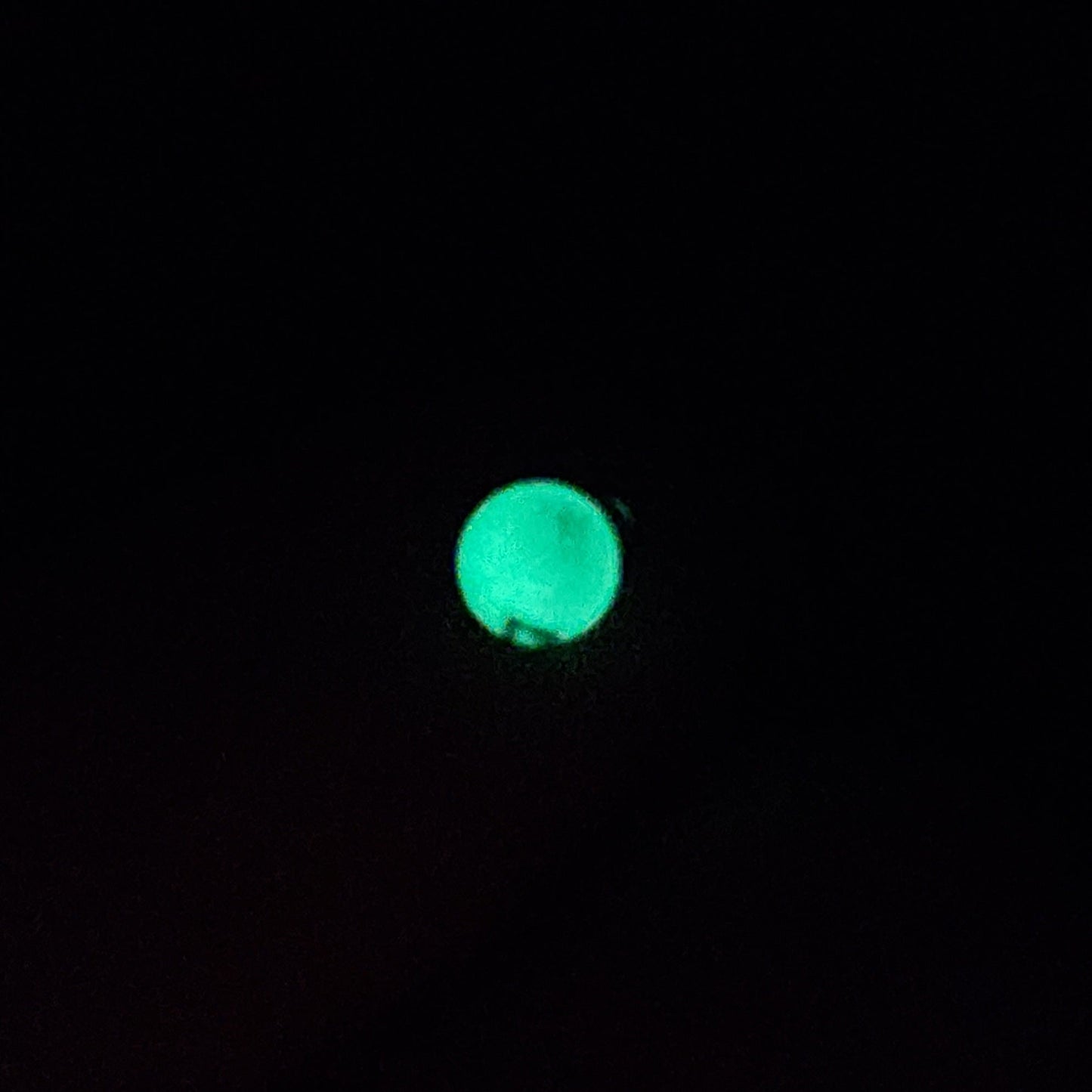 Glowing green submerged sinker on a black background