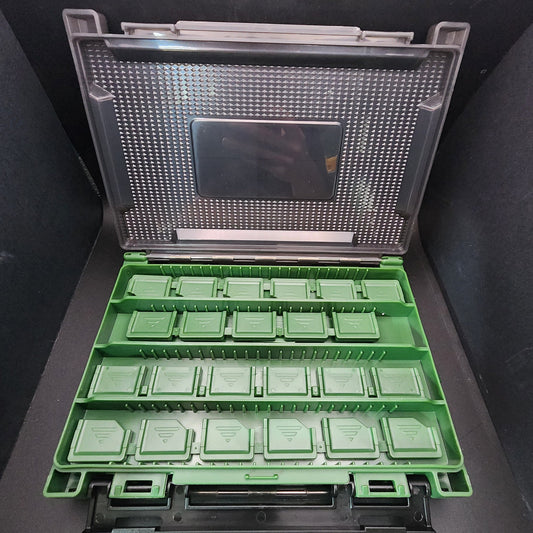 Green plastic compartments in a clear plastic case on a dark surface