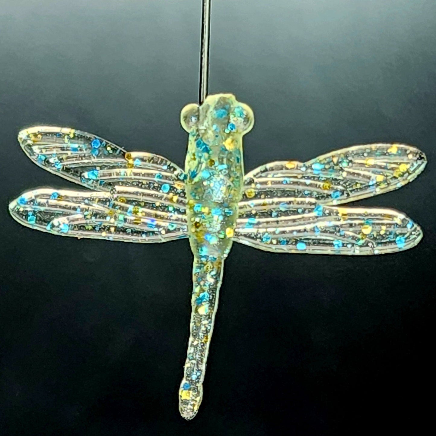 Decorative dragonfly ornament with gemstones on a black background