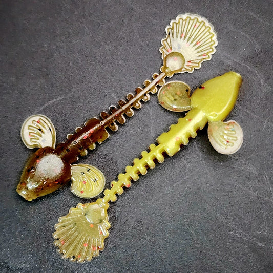 fish lures with shell-like decorations on a dark surface