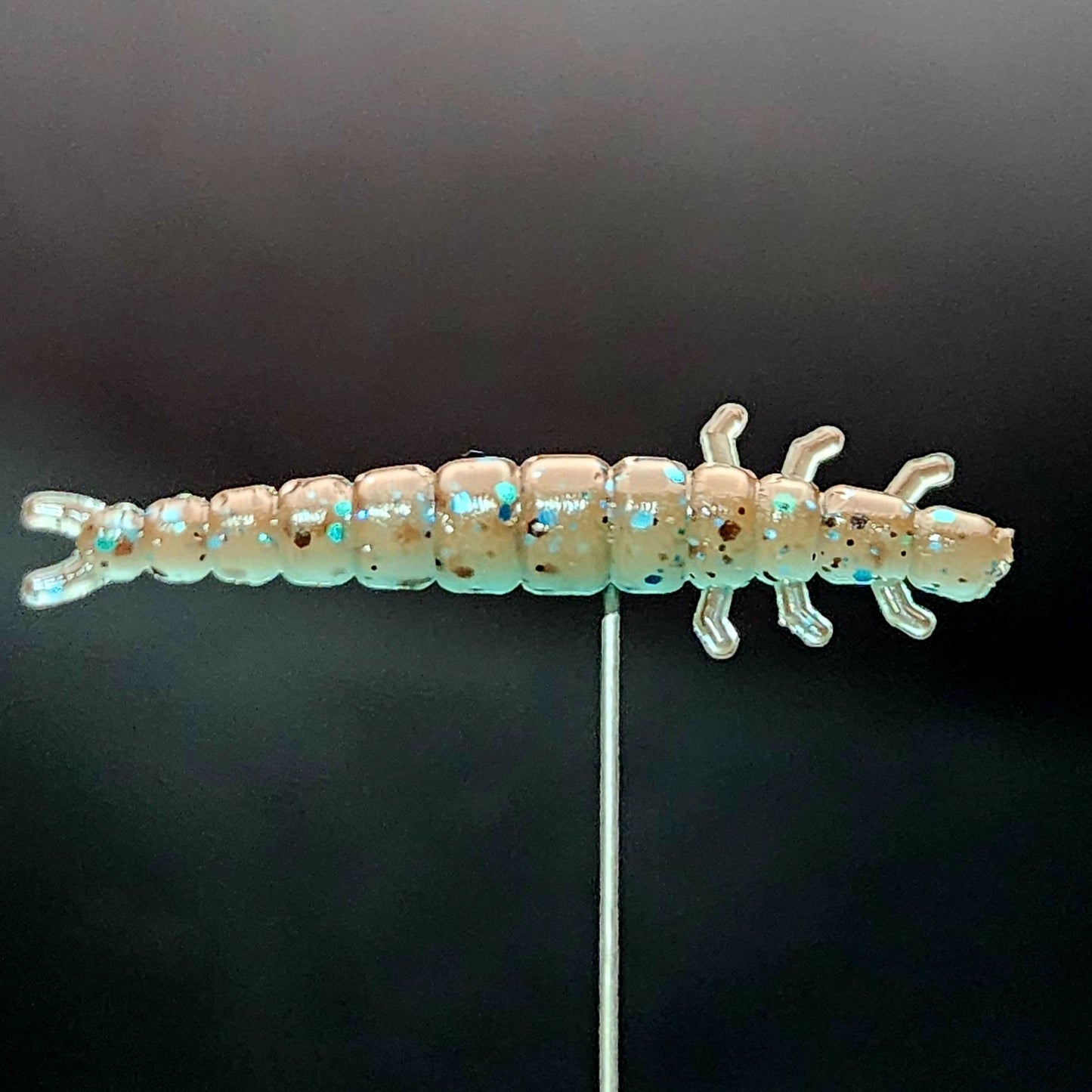 Fishing lure shaped like a worm on a black background