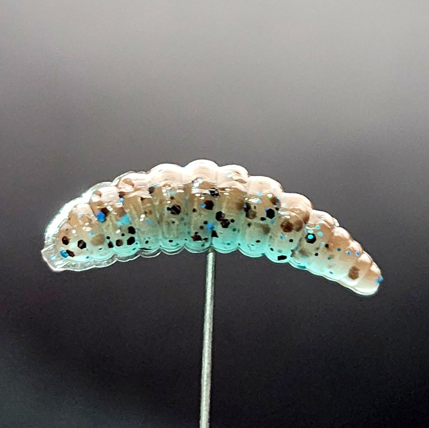 fishing lures shaped like a caterpillar on a gray background