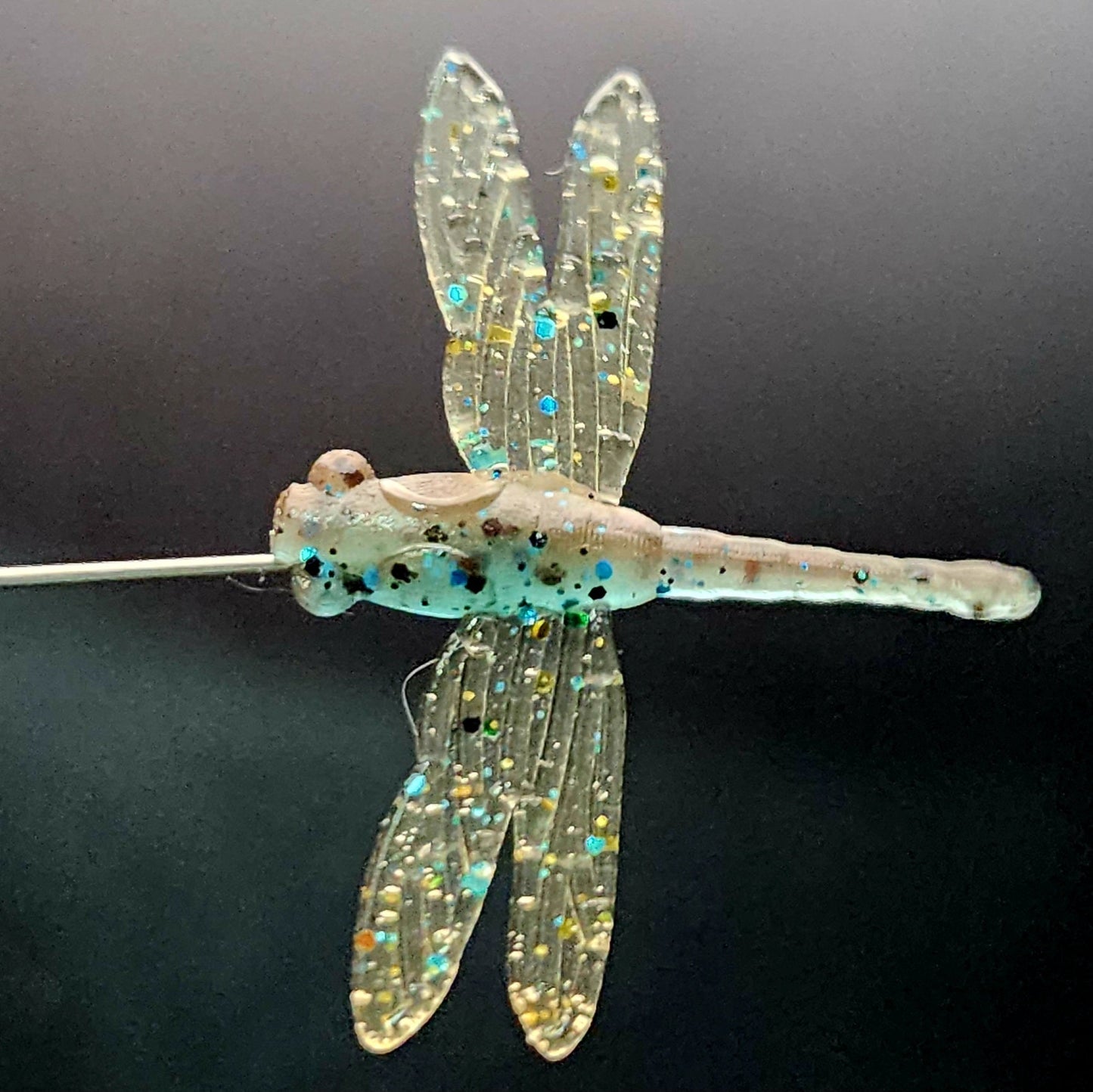 Dragonfly-shaped fishing lure on a black background