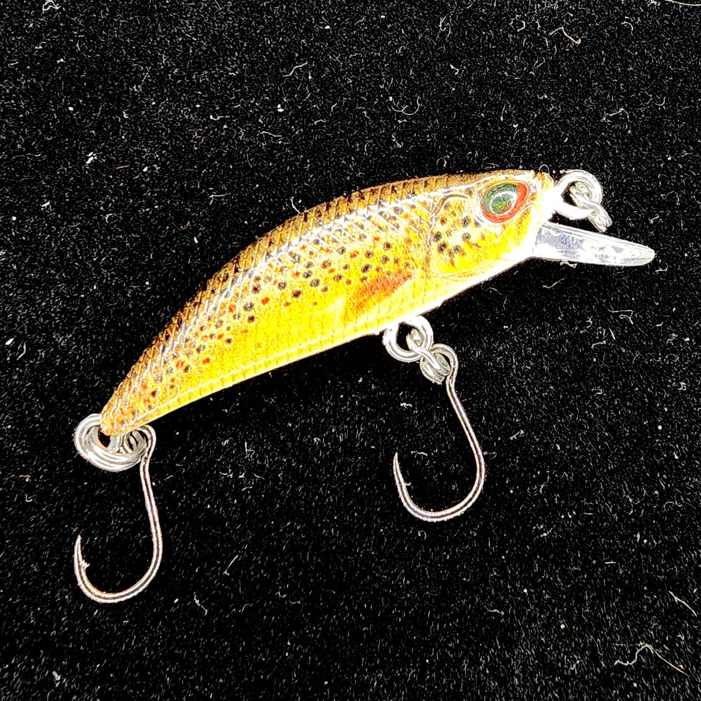 Yellow and orange fishing lure with a black background