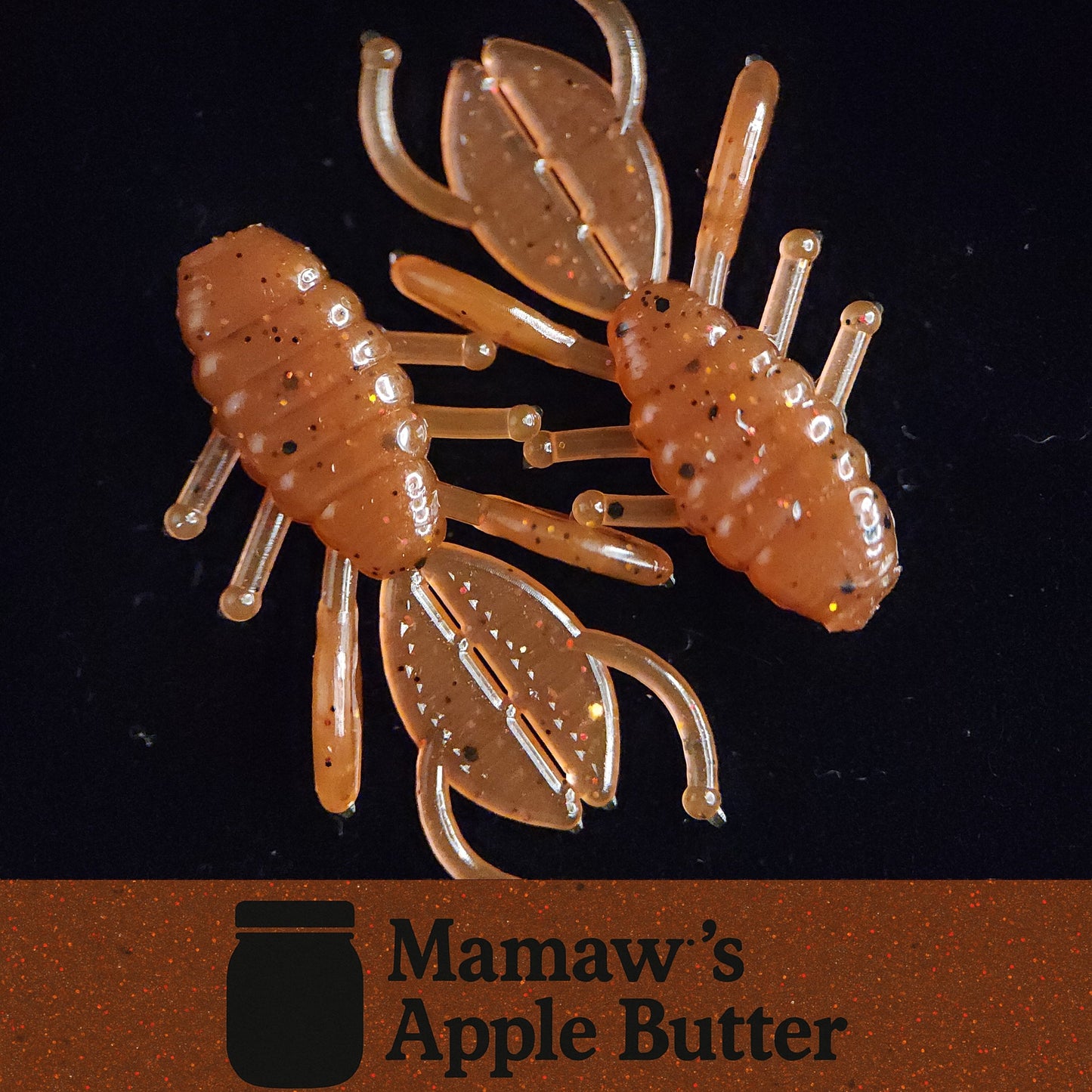 Transparent crawfish-shaped fishing lure with 'Mamaw's Apple Butter' branding on a dark background.