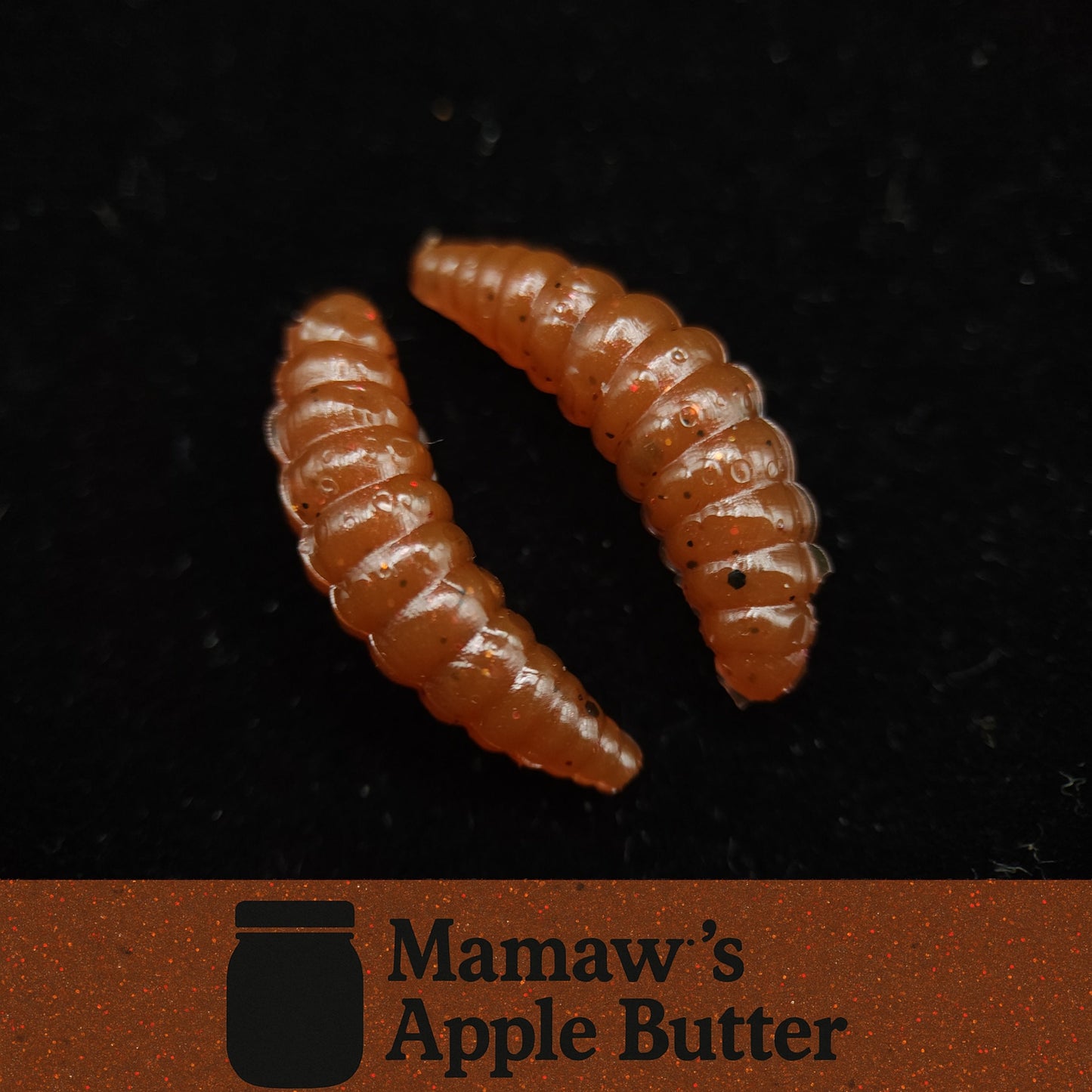 Two brown fishing lure worms on a black background with 'Mamaw's Apple Butter' logo.