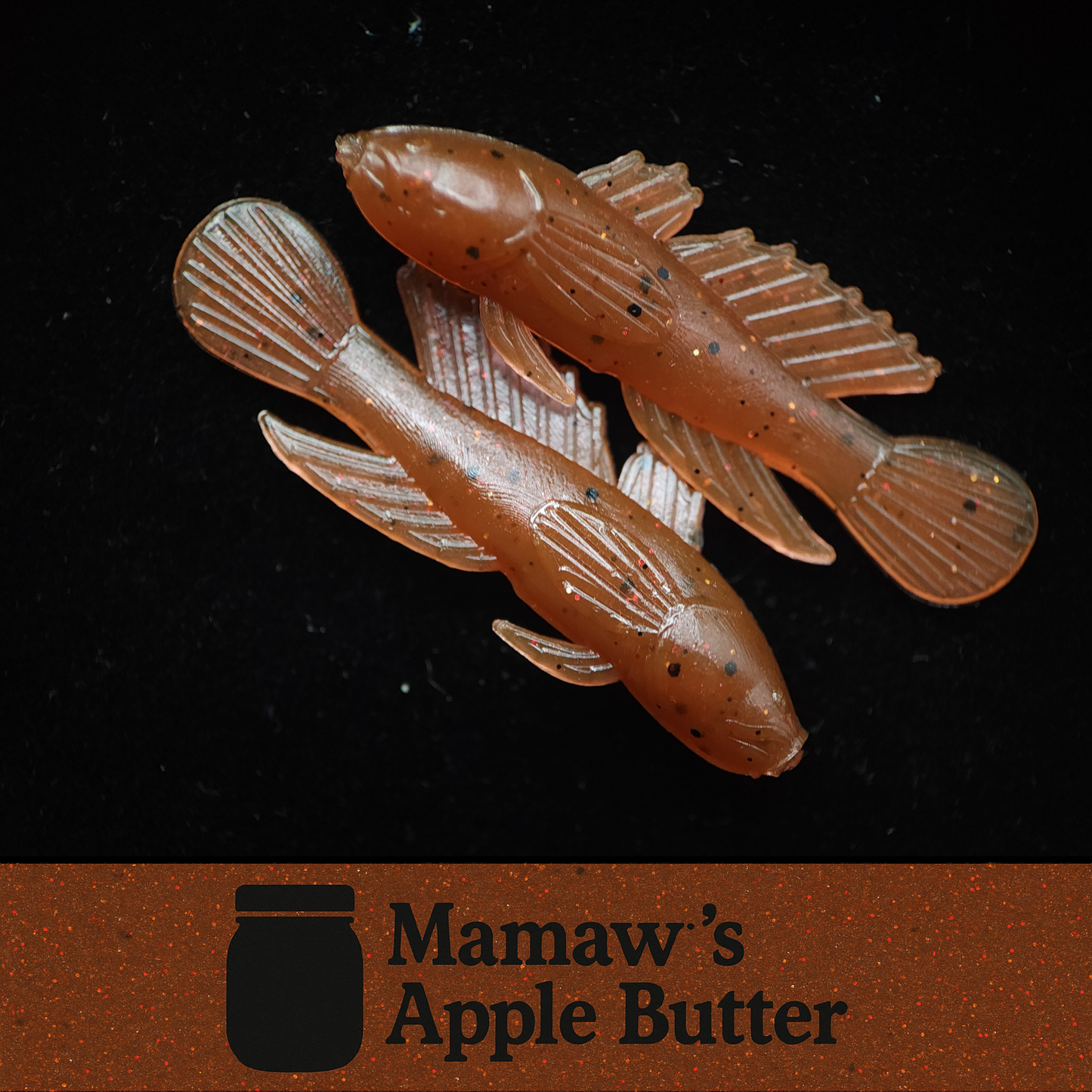 Two fish-shaped fishing lures on a black background with 'Mamaw's Apple Butter' branding.