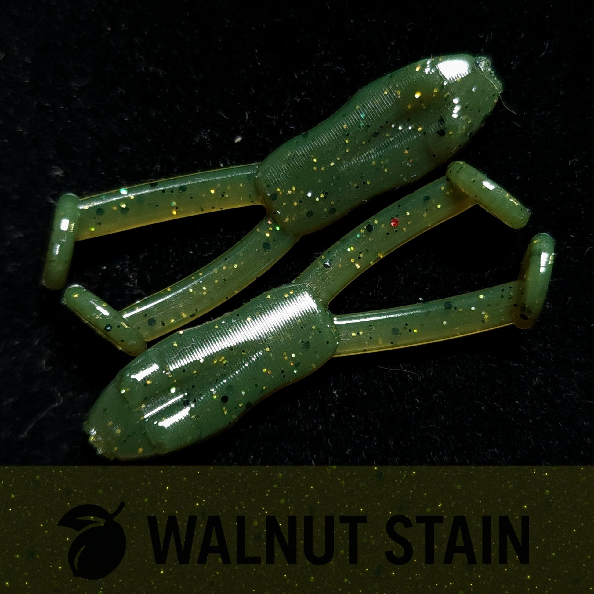 Two green fishing lures with speckles on a black background, labeled 'Walnut Stain'.