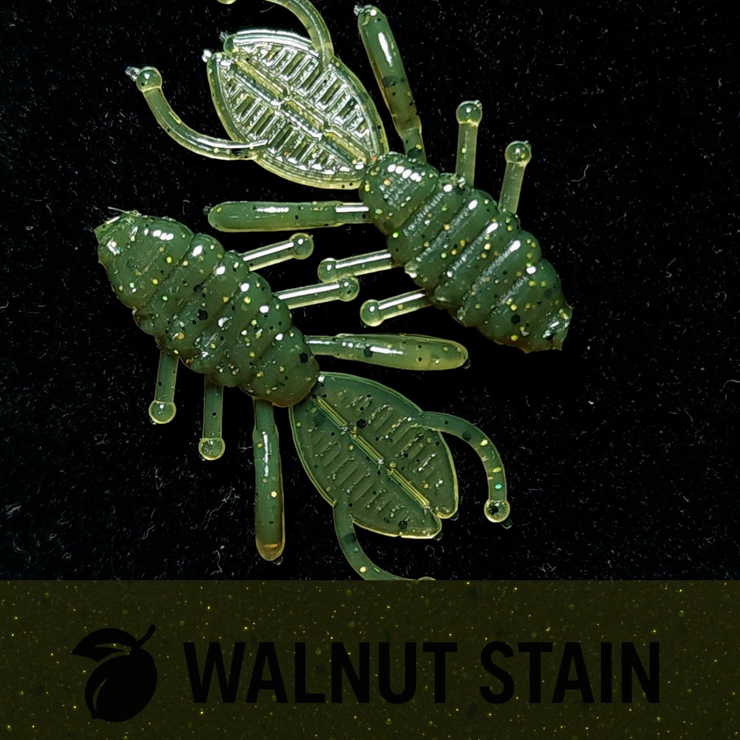 Two green insect-shaped fish lures on a black background with 'Walnut Stain' text.