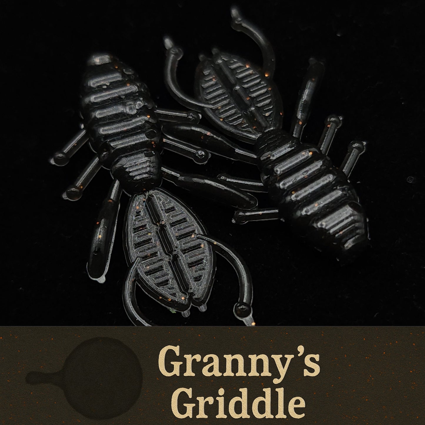 Black plastic scorpion-shaped fishing lures with 'Granny's Griddle' branding on a black background