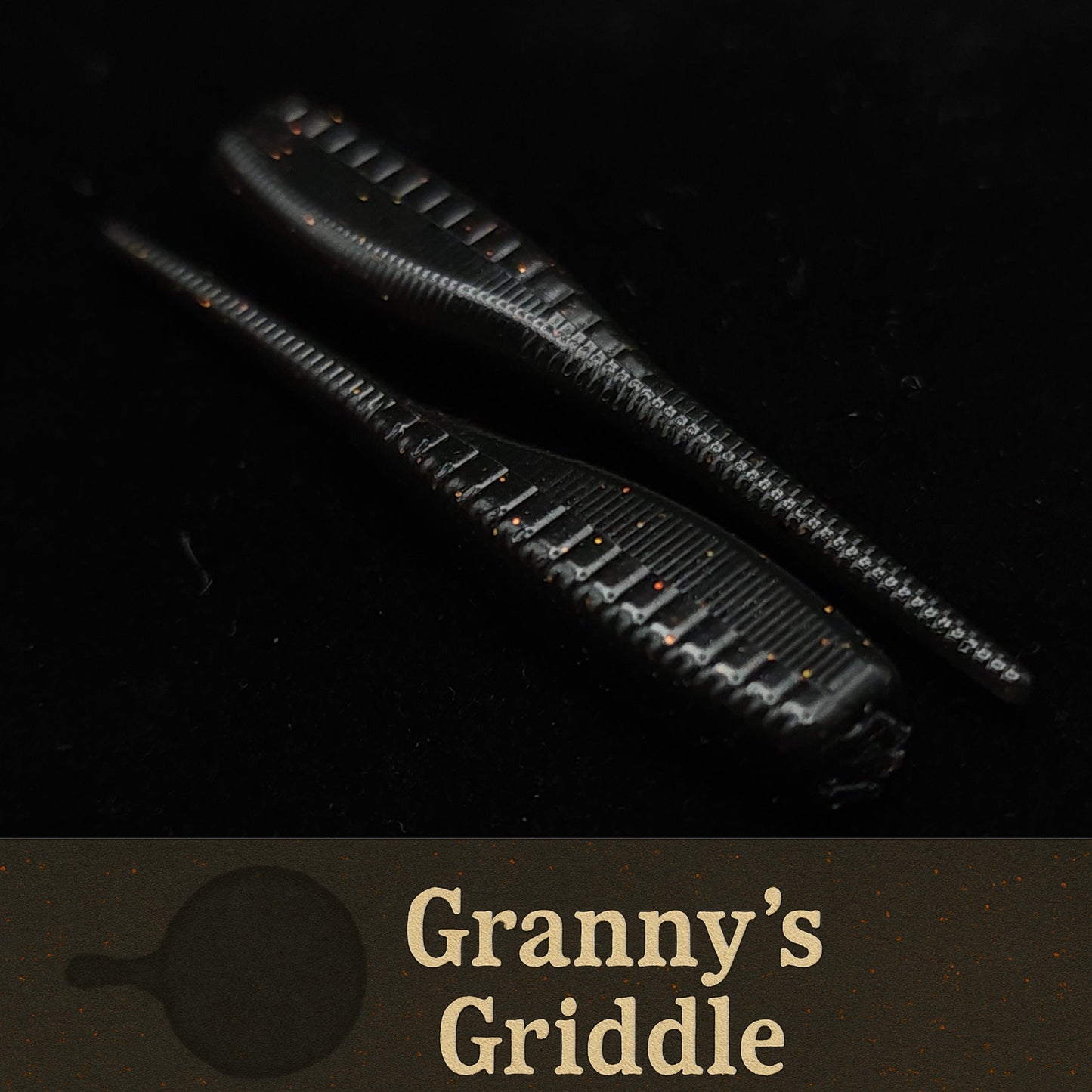 Black fishing lures with 'Granny's Griddle' branding on a dark background