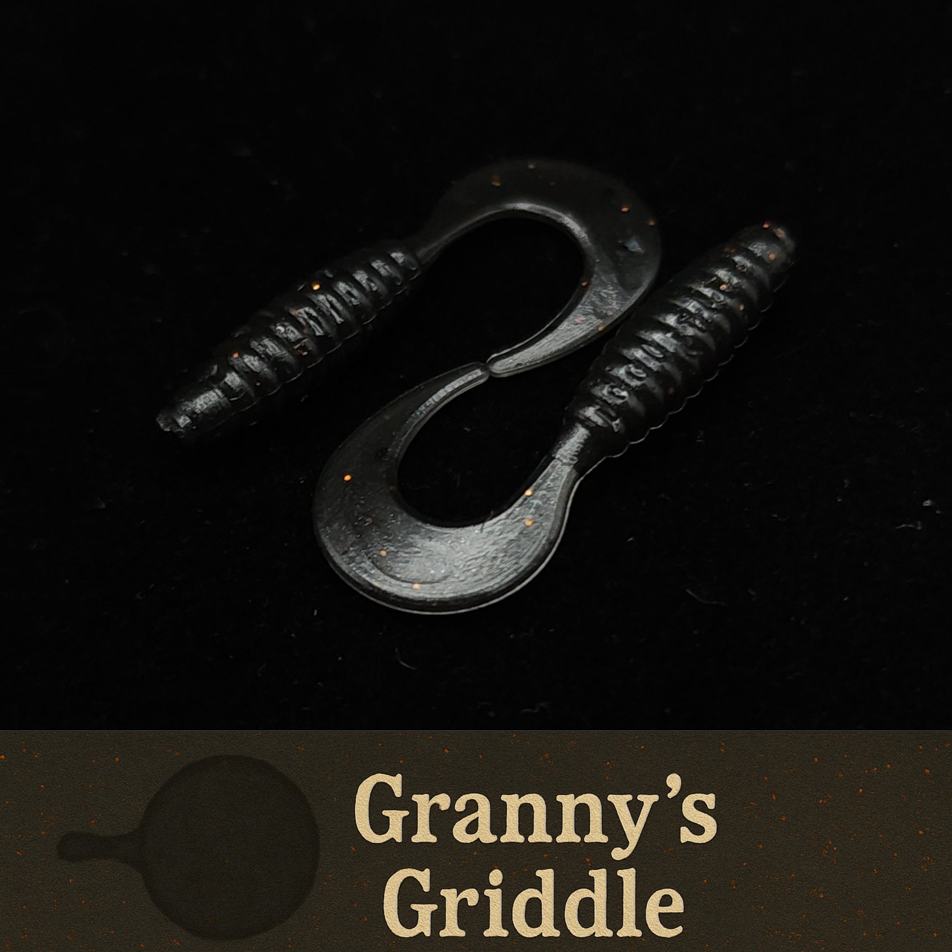 Black fishing lures with 'Granny's Griddle' branding on a dark background