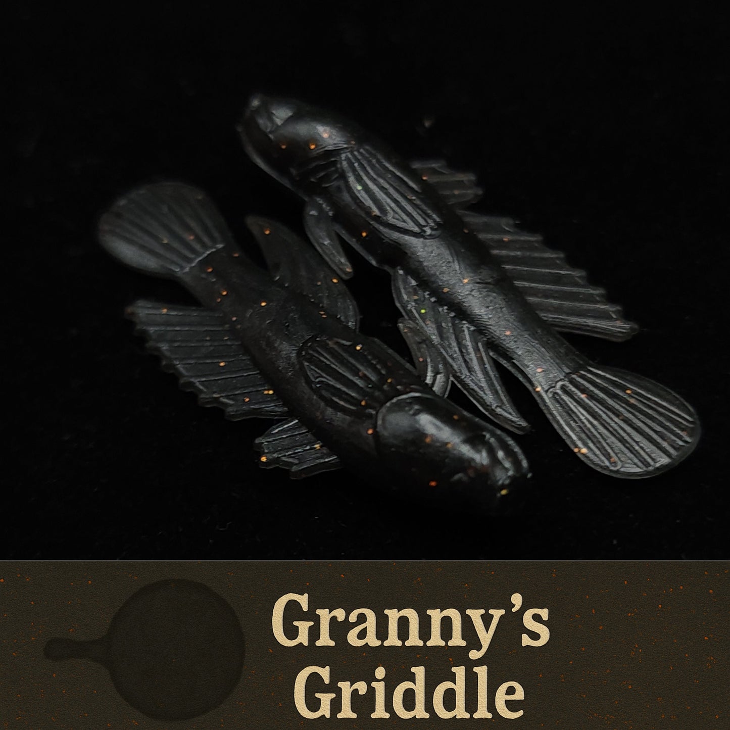 Black fishing lures with 'Granny's Griddle' branding on a dark background