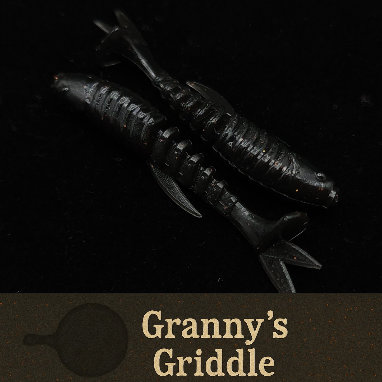 Black fishing lure labeled 'Granny's Griddle' on a dark background