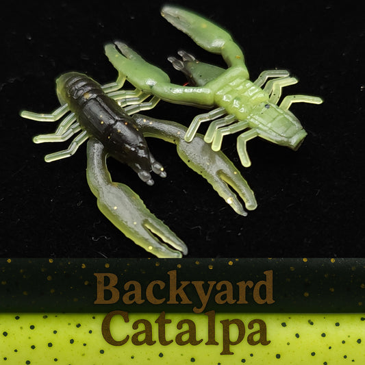 Two crawfish shaped fishing lures on a black background with 'Backyard Catalpa' branding.