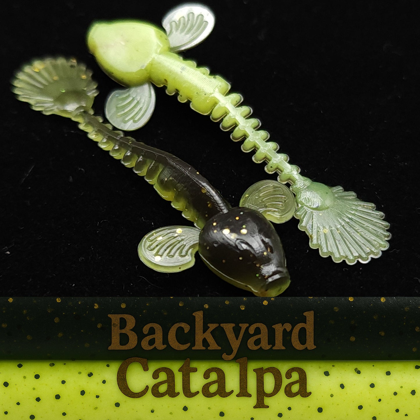 Fishing lure resembling a tadpole with shell-like structures on a black background, labeled 'Backyard Catalpa'.