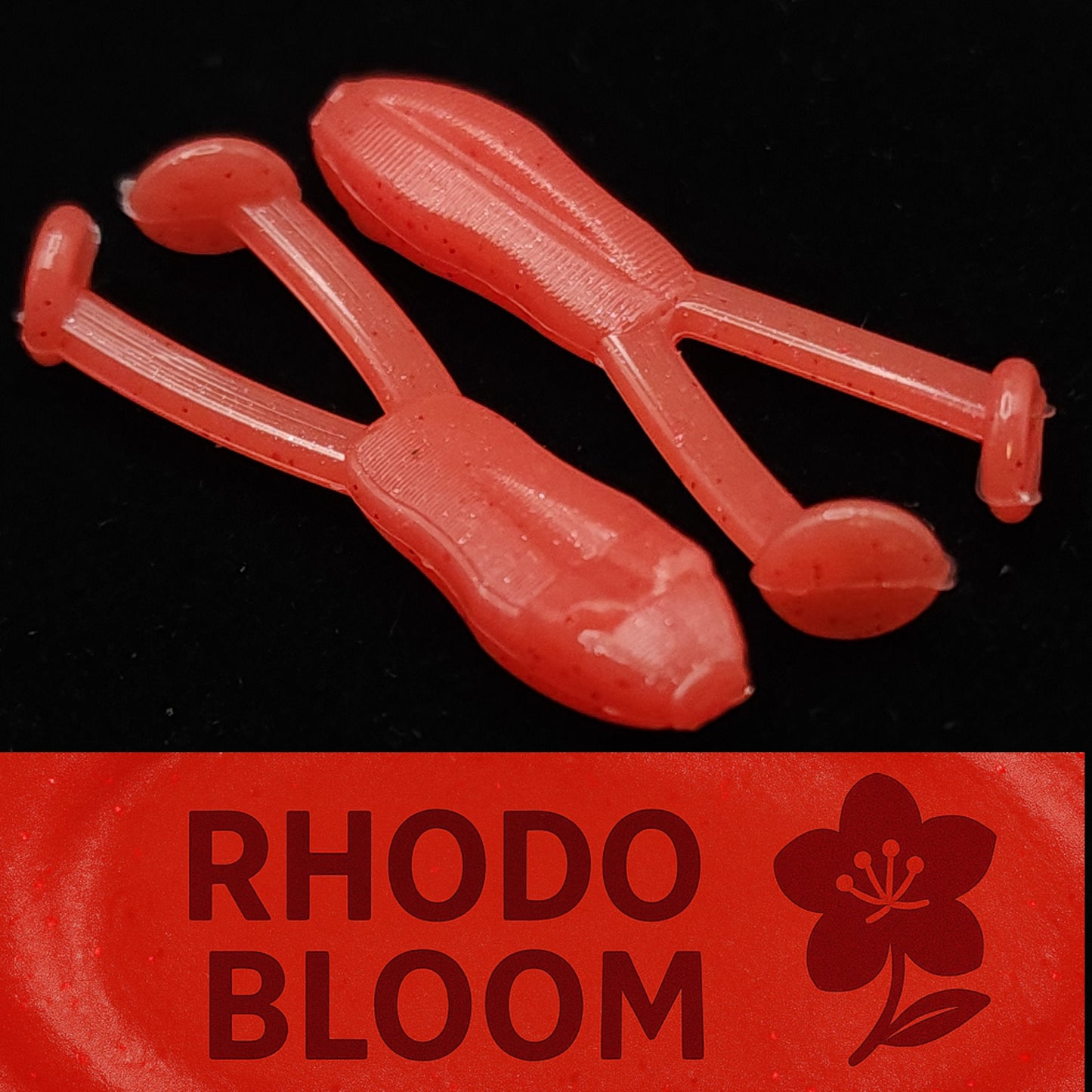 Red plastic frog shaped fishing lures with 'Rhodo Bloom' branding on a black background