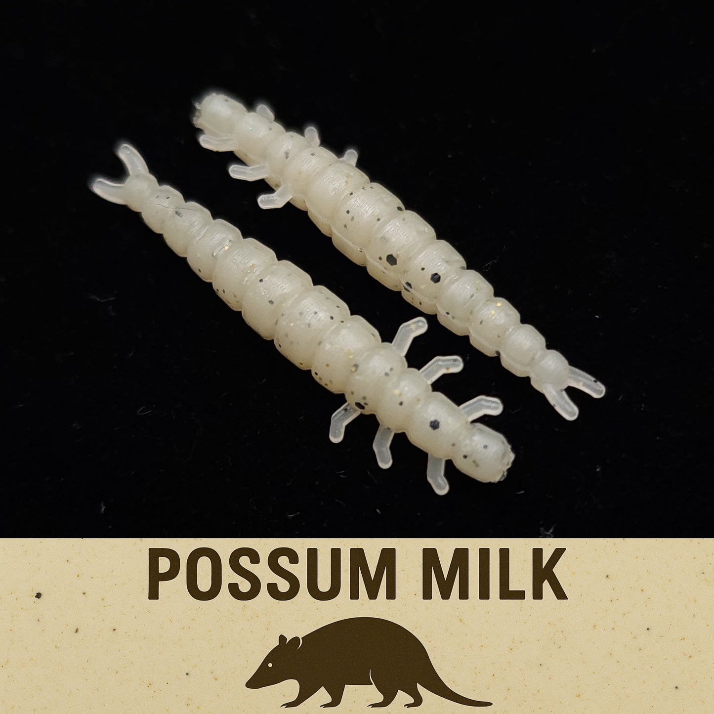 Two white larva-like fishing lures on a black background with 'Possum Milk' text and logo.