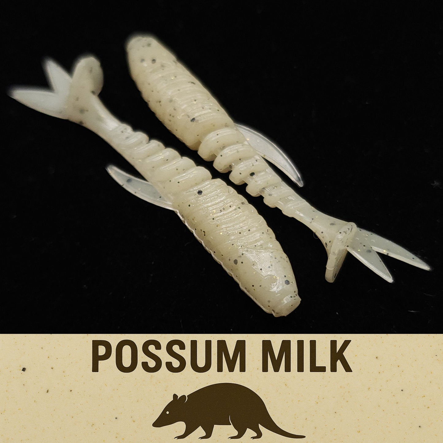 Two white fishing lures with a 'Possum Milk' label on a black background