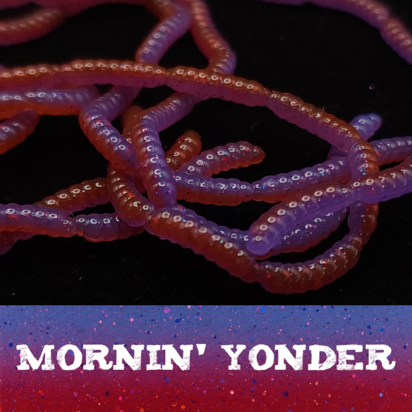 Close-up of red and purple Micro Maggot Fly Larvae fake bait with 'Mornin' Yonder' text on a dark background