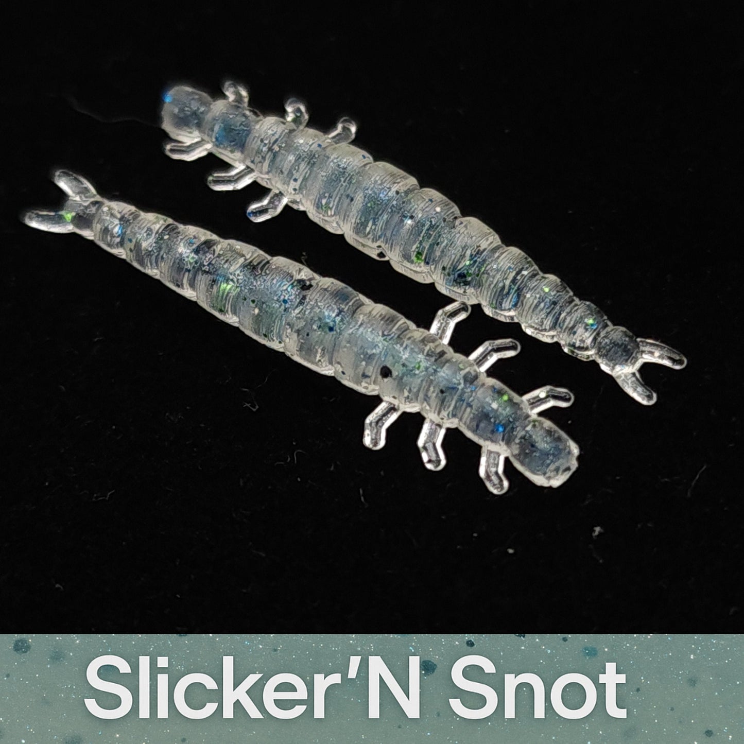Two transparent blue fishing lures with legs on a black background, branded 'Slicker'N Snot'.