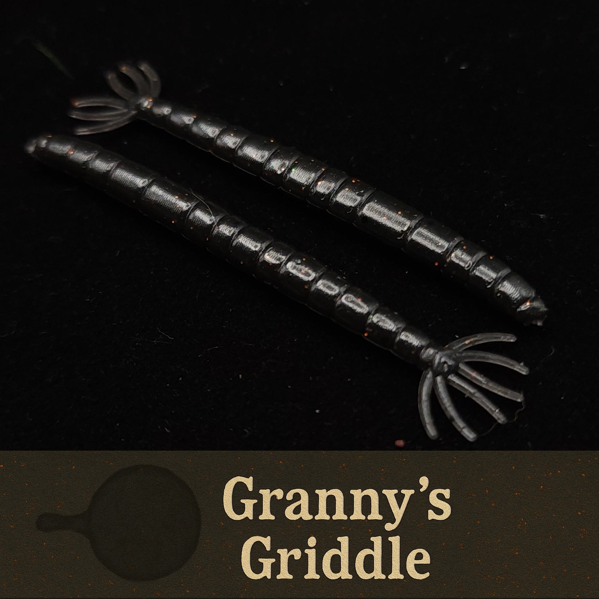 Two black  fishing lures on a dark background, labeled 'Granny's Griddle'.