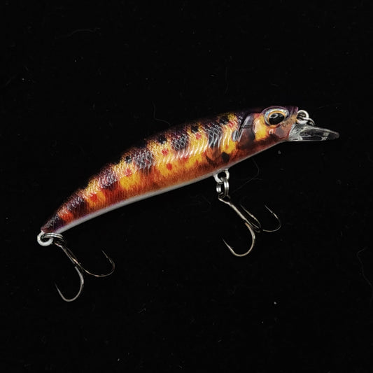 Fishing lure with a fiery color pattern on a black background