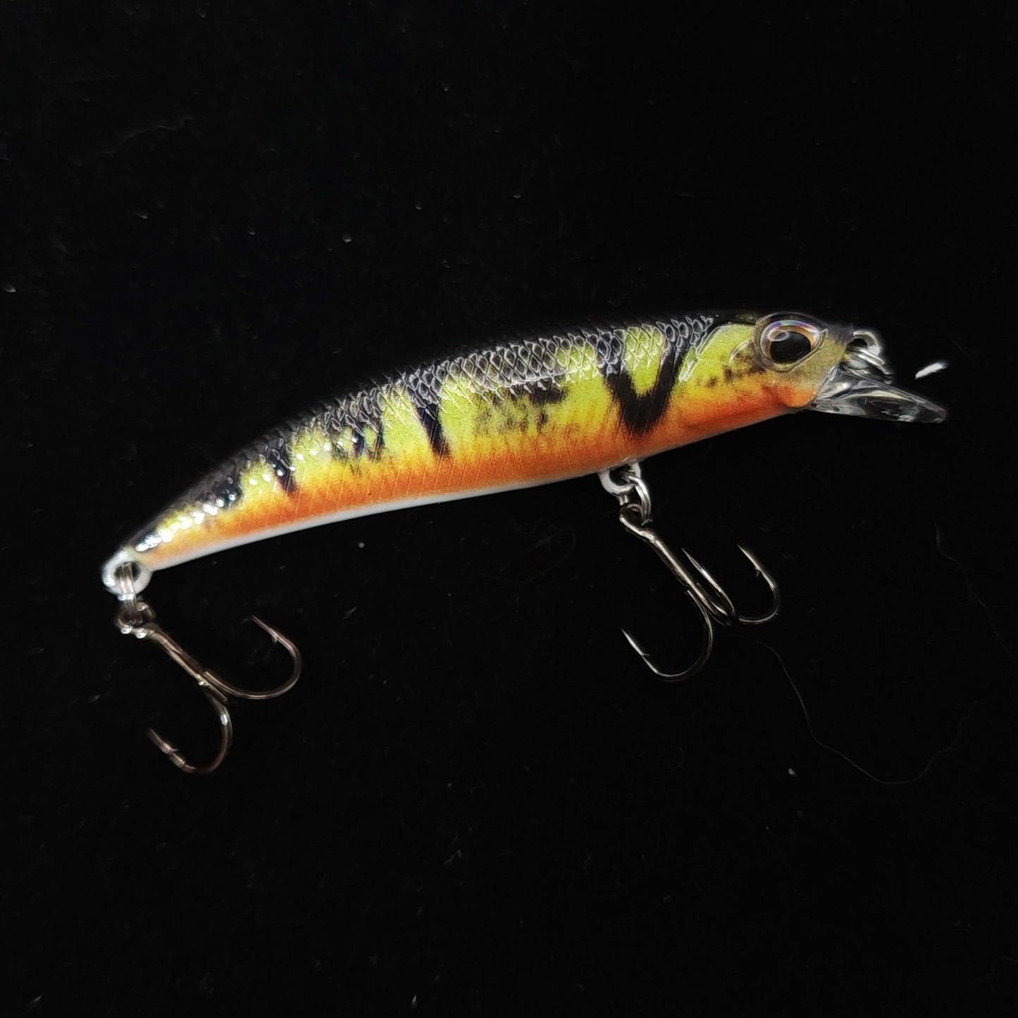Fishing lure with a striped pattern on a black background