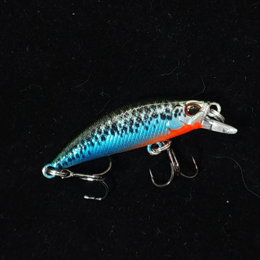 Fishing lure with blue and orange colors on a black background
