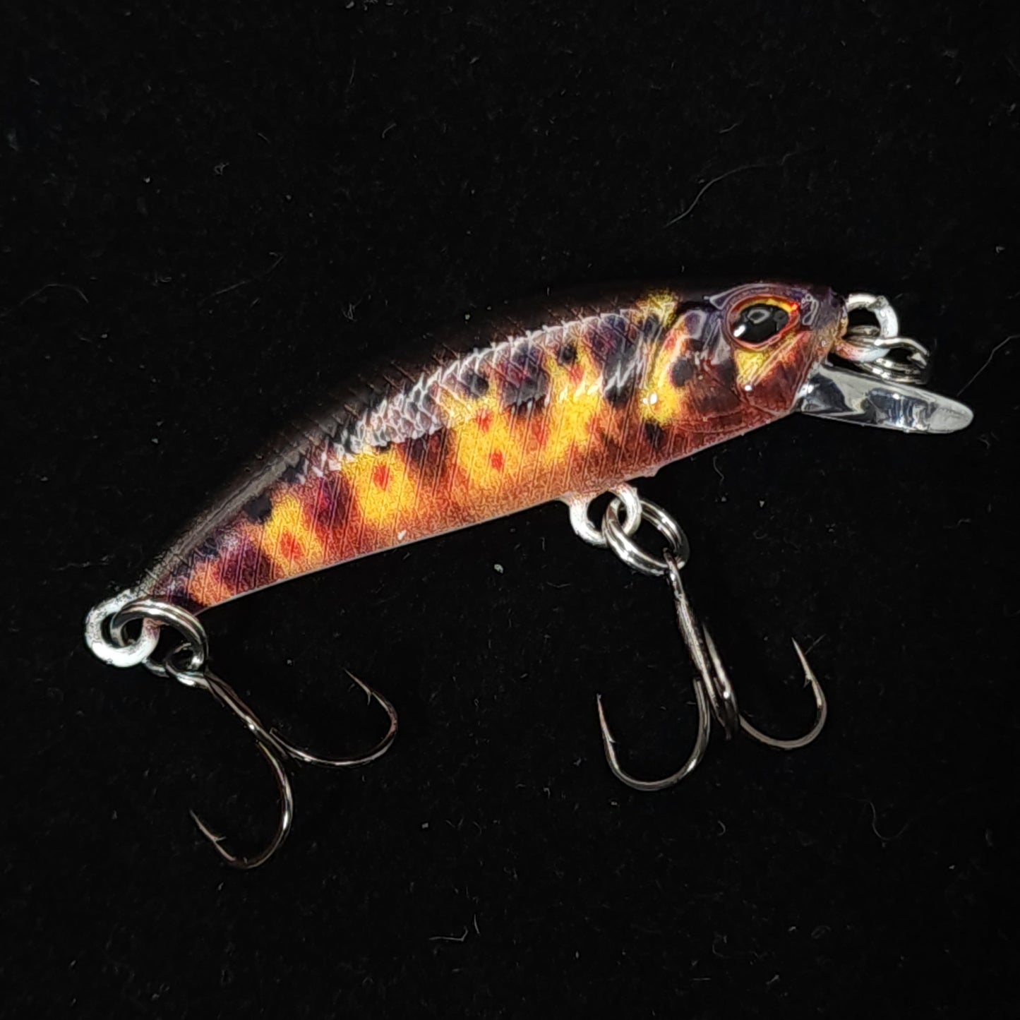 Fishing lure with a colorful pattern on a black background