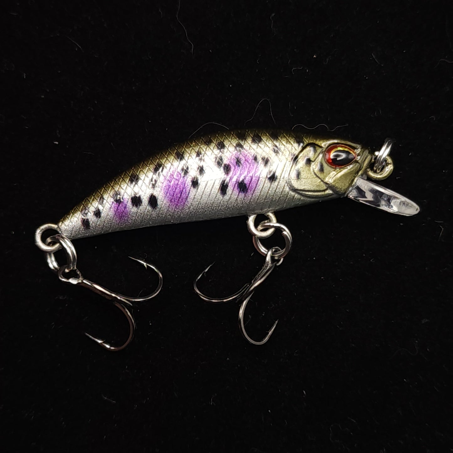Fishing lure with purple and black pattern on a black background