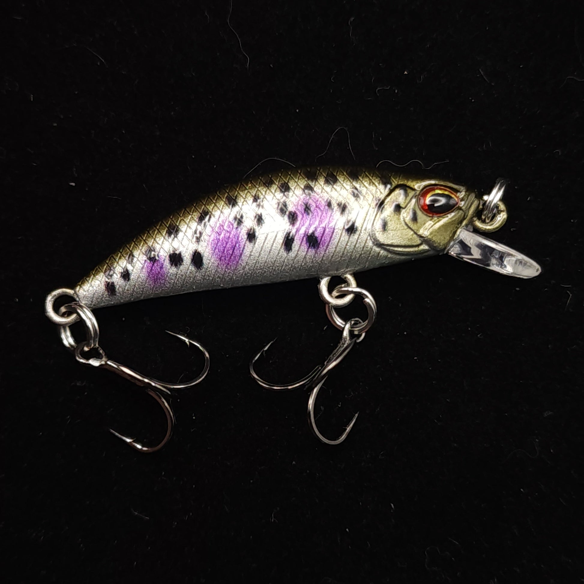 Fishing lure with purple and black pattern on a black background
